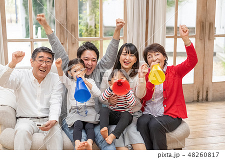 パラリンピックをテレビ観戦し六人家族全員で応援する幸せそうな三世代家族の写真素材