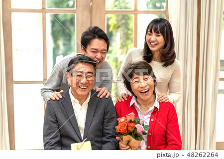 父の日母の日花束プレゼント親孝行な息子娘夫婦笑顔が絶えない家庭仲良し家族の見本の写真素材