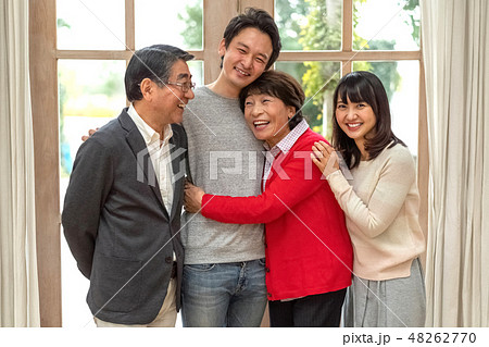 笑いで何でも吹き飛ばすパワフル親子四人家族の素敵な笑顔の写真素材