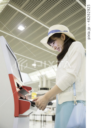 空港で自動チェックイン機を使う女性 48262925