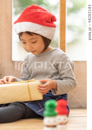 クリスマスプレゼントを貰い嬉しそうな可愛い少女幼稚園児の写真素材 4631