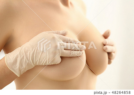 Female hand in gloves holding breast closeup Female hand in gloves holding breast closeup 48264858