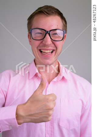 Face of young happy nerd businessman looking excited while giving thumbs up 48267123