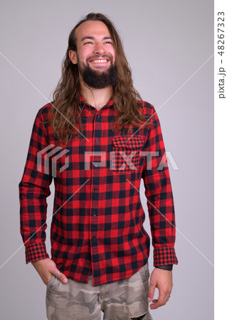 Portrait of young happy bearded hipster man thinking 48267323