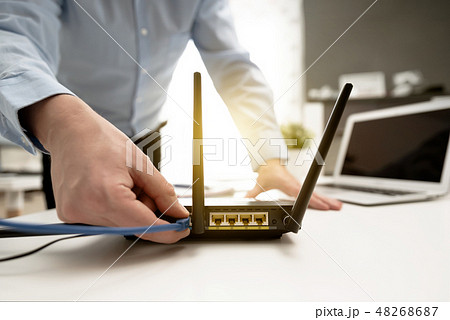 Man connects the cable to the router's socket Man connects the cable to the router's socket 48268687