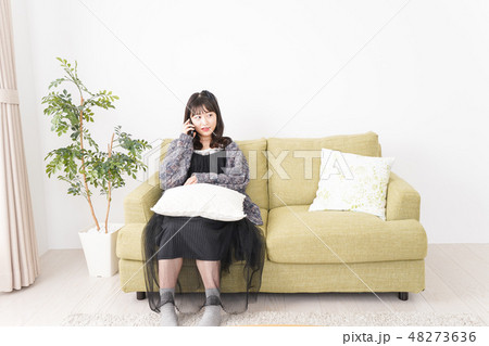 家でスマートフォンを使う若い女性 48273636