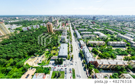 Aerial city view with crossroads and roads, houses, buildings, parks and parking lots. Sunny summer Aerial city view with crossroads and roads, houses, buildings, parks and parking lots. Sunny summer 48276318