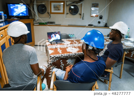 Seamen crew onboard a ship or vessel having fun watching movie Seamen crew onboard a ship or vessel having fun watching movie 48277777