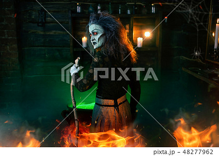 Scary witch cooking green brew and reads the spell Scary witch cooking green brew and reads the spell 48277962