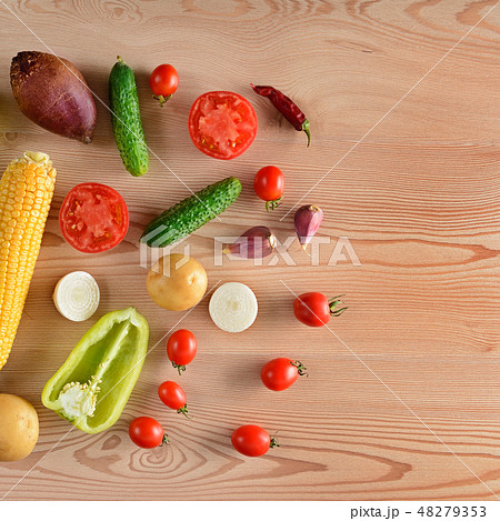 Vegetables laid out on a wooden table. Vegetables laid out on a wooden table. 48279353