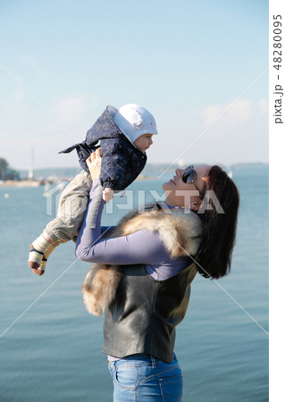 Mom and son have fun on the shore of the blue sea 48280095