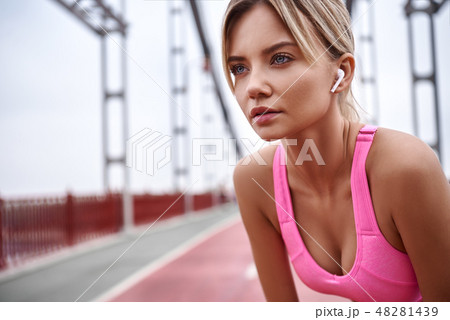 Tired after jogging. Beautiful young woman in sports clothing bending and looking tired while 48281439