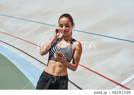 I'll train again, but not until the music's right. Runner on the stadium track. Woman summer fitness I'll train again, but not until the music's right. Runner on the stadium track. Woman summer fitness 48281596