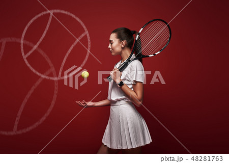 Talk with your raquet, play with your heart. Young tennis player standing isolated over red 48281763