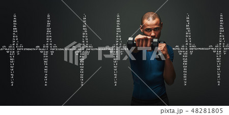 Everything is possible. Dark skinned sportsman working out with dumbbells over dark background Everything is possible. Dark skinned sportsman working out with dumbbells over dark background 48281805