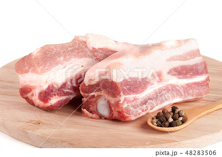 pieces of pork with peppercorn on a cutting board isolated on white background pieces of pork with peppercorn on a cutting board isolated on white background 48283506