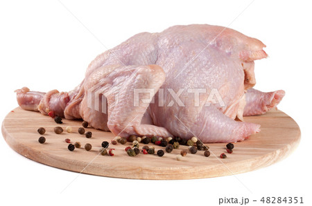 raw chicken carcass with peppercorns on the cutting board isolated on white background 48284351