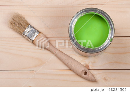 green paint in the bank to repair and brush on the light wooden background green paint in the bank to repair and brush on the light wooden background 48284503