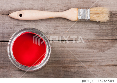 red paint in the bank to repair and brush on the old wooden background with copy space for your text red paint in the bank to repair and brush on the old wooden background with copy space for your text 48284504