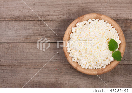 Cottage cheese in a wooden bowl on old wooden background with copy space for your text. Top view 48285497