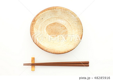 白いテーブルに置かれた土製の皿と箸 48285916