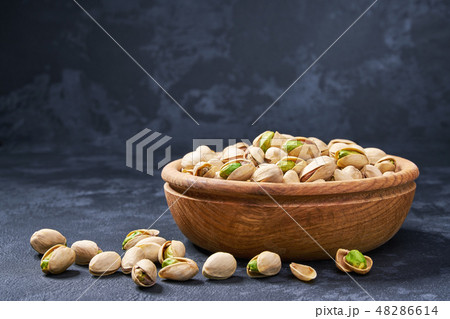Pistachios in wooden bowl on black background  48286614