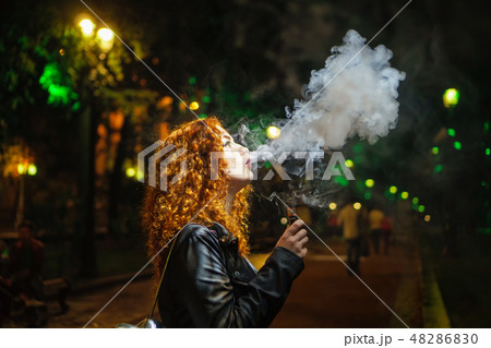 Girl smokes electronic cigarette Girl smokes electronic cigarette 48286830