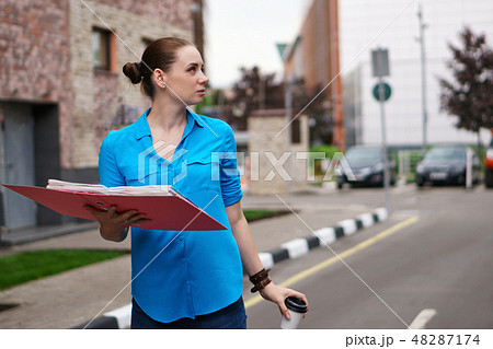 Girl with folders for papers and coffee Girl with folders for papers and coffee 48287174