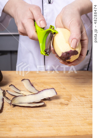 woman cook cleans potatoes 48288474