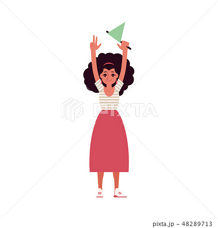 A young curly brunette woman in a skirt and top, raised her hands up and holds the flag. 48289713