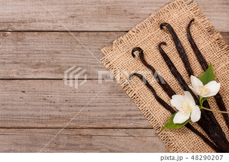 Vanilla sticks with flower and leaf on a old wooden background with copy space for your text. Top 48290207