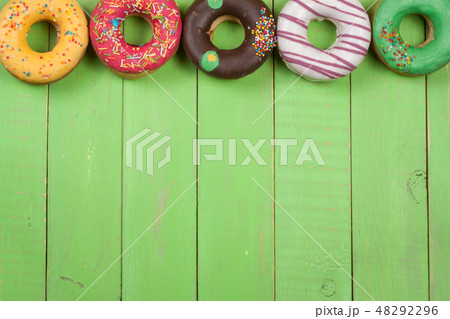 glazed donuts on a green wooden background with copy space for your text. Top view glazed donuts on a green wooden background with copy space for your text. Top view 48292296