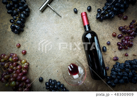 A bottle of red wine with grapes A bottle of red wine with grapes 48300909