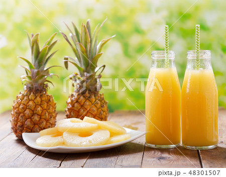 bottles of pineapple juice with fresh fruits 48301507