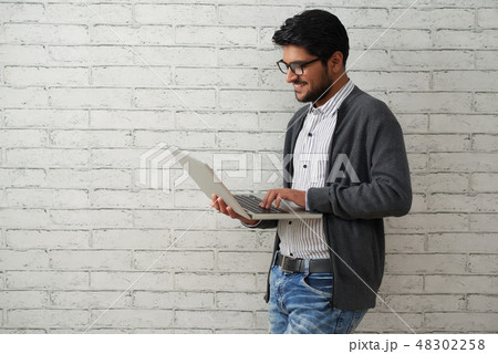 Cheerful programmer with laptop Cheerful programmer with laptop 48302258