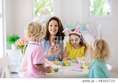 Mother and kids, family coloring Easter eggs. 48302710