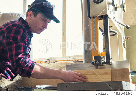 Construction worker cutting wooden board Construction worker cutting wooden board 48304160