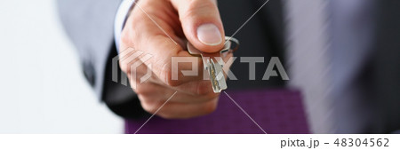 Male hand hold silver key giving Male hand hold silver key giving 48304562
