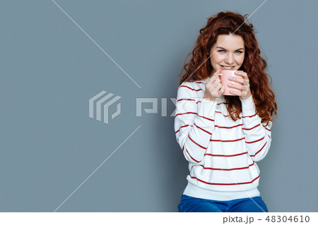 Cheerful joyful woman having tea Cheerful joyful woman having tea 48304610