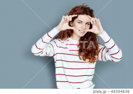 Joyful nice woman putting her fingers together 48304636