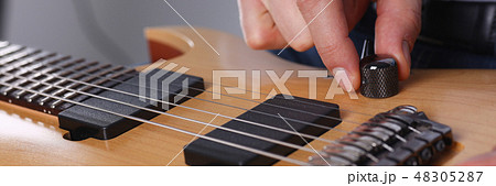 Male arms playing classic shape electric guitar Male arms playing classic shape electric guitar 48305287