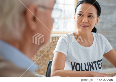 Charming volunteer and senior man talking Charming volunteer and senior man talking 48307280