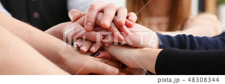 Group of people in suits crossed hands in pile for win Group of people in suits crossed hands in pile for win 48308344