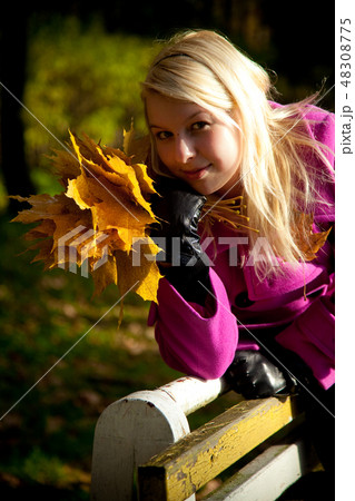Young blonde woman in violet coat in park 48308775