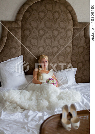 Young sexy blonde woman in bedroom sitting on bed Young sexy blonde woman in bedroom sitting on bed 48309486
