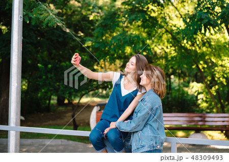 Image of young amazing women friends students take selfie Image of young amazing women friends students take selfie 48309493