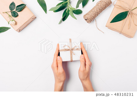Woman's hands holding small gift box 48310231