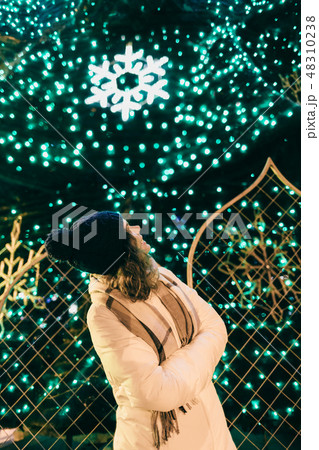 Young pretty woman standing near glittering lights Young pretty woman standing near glittering lights 48310238