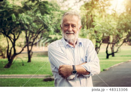Portrait of happy senior man standing in the park. 48313306