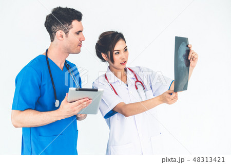 Doctors working with x ray film of patient head. Doctors working with x ray film of patient head. 48313421
